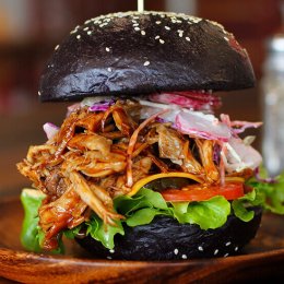 Bourbon pork burger with tangy apple slaw on a black brioche bun