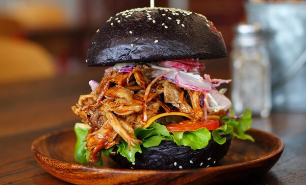 Bourbon pork burger with tangy apple slaw on a black brioche bun