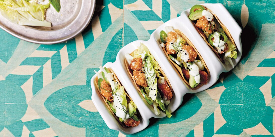 Munch on sesame crunch chicken tacos with cos, avocado and zesty crema